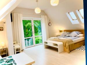 a bedroom with a bed and a large window at Domek La Pergola in Łeba
