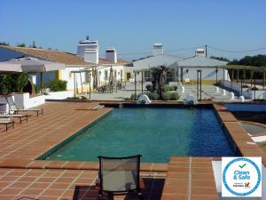 a swimming pool in front of a house at Quinta Da Espada in Évora