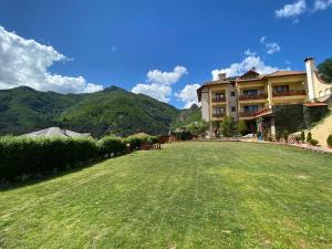 a large yard with a building and mountains in the background at Kris Guest House in Devin