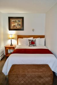 a bedroom with a large bed with a red blanket at Schott's Lake Conference & Resort in Sundre