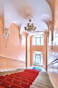 a room filled with red and white furniture and a stairway at Bear Fountain Residence in Prague