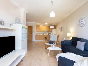 Una sala de estar con un sofá azul y una cocina. en Apartment Sunny Tejita by Interhome, en La Tejita