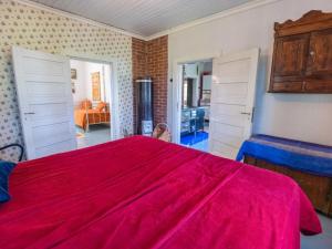 una camera con letto rosso e un soggiorno di Holiday Home Piispasen torppa by Interhome 