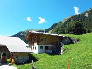 una casa in cima a una collina con un campo verde di Apartment Linders Vorsass - Alphütte by Interhome a Rougemont
