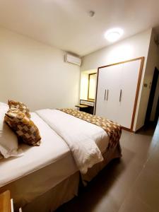 ein Schlafzimmer mit einem großen Bett und einem weißen Schrank in der Unterkunft Passion Hotel Villas in Chamis Muschait