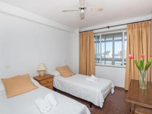 een slaapkamer met 2 bedden en een raam met roze bloemen bij Apartment Eurosol-3 by Interhome in Torremolinos