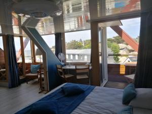 a bedroom with a bed and a balcony with a table at Hotel De La Mer in Trégastel