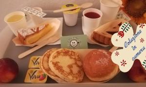 a tray of breakfast food with pastries and drinks at Euro Hotel in Tirrenia