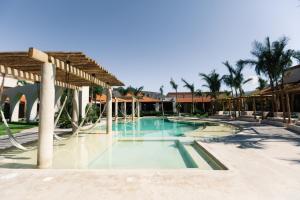 een zwembad in een resort met palmbomen bij Hacienda 1800 in Cuatrociénegas de Carranza