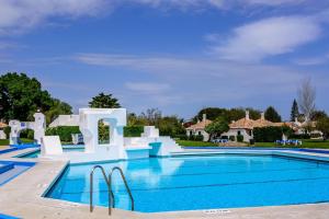 a large swimming pool with blue water at Studio Pedras d'el Rei in Santa Luzia