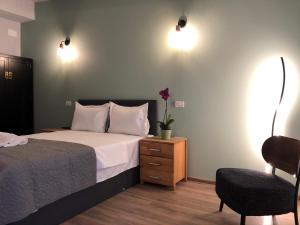 a bedroom with a bed and a chair and lights at Casa Maranta in Costinesti