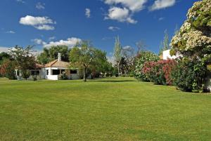 a house with a yard with green grass and flowers at Studio Pedras d'el Rei in Santa Luzia