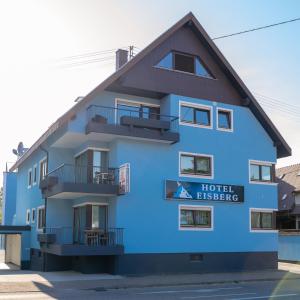 ein blaues Gebäude mit einer Botschaft des Hotels in der Unterkunft Eisberg Gästehaus & De Luxe Appartements in Friesenheim