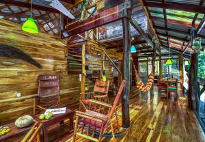 une peinture d'une cabane en rondins avec des fauteuils à bascule dans l'établissement Congo Bongo EcoVillage Costa Rica, à Puerto Viejo