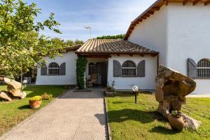 a white house with a rock in front of it at Casa Stella Di Madel in Flumini di Quartu