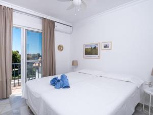 a white bedroom with a large white bed and a window at Holiday Home Sol de Estepona by Interhome in Estepona