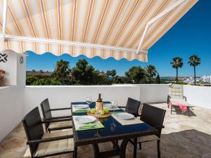 une salle à manger avec une table et des chaises sur une terrasse dans l'établissement Holiday Home Sol de Estepona by Interhome, à Estepona