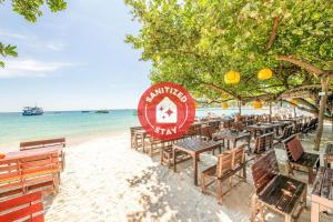 - un groupe de tables et de chaises sur une plage dans l'établissement Tom Pizza Resort, à Ko Samet