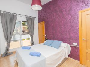 a bedroom with a bed and a purple wall at Holiday Home Nova by Interhome in Segur de Calafell