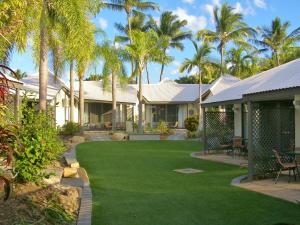 a lush green lawn with palm trees and palm trees at Island Leisure Resort in Nelly Bay