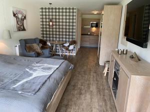 a bedroom with a bed and a living room at Apartment BERGliebe - schnuckelig, ruhige und zentrale Lage in Schliersee