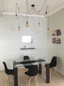 a dining room with a black table and chairs at Cantinho do Sonho in Maia