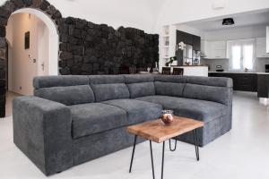 a living room with a gray couch and a table at George Farm Land in Karterados