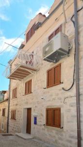 a building with wooden windows and a air conditioner at Villa Madonna della Strada A3 in Dubrovnik