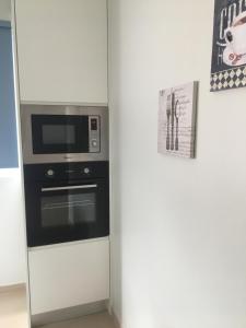 a kitchen with a microwave and a stove at Cantinho do Sonho in Maia