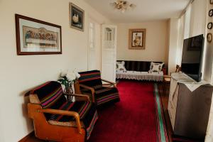 a living room with two chairs and a flat screen tv at Căsuţa de lângă Lac in Saharna Nouă