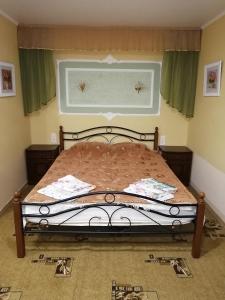 エイスクにあるGuesthouse Ugra na Primorskomの緑のカーテン付きの窓が備わるベッドルームのベッド1台