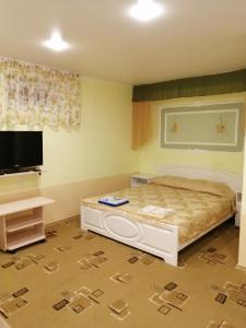 エイスクにあるGuesthouse Ugra na Primorskomのベッドルーム(ベッド1台、薄型テレビ付)