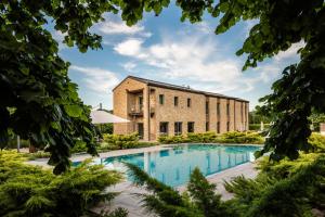 an external view of a brick building with a swimming pool at Agriresort Villa Gelso - Adults and Pet friendly in Vesime