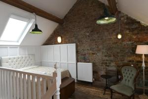 a bedroom with a bed and a brick wall at The Milk House in Tobermore