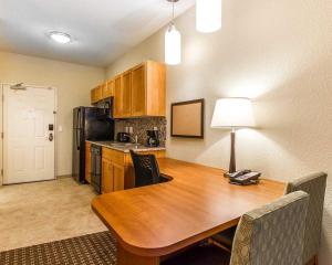 a kitchen with a table and chairs and a refrigerator at Hawthorn Suites by Wyndham Minot in Minot