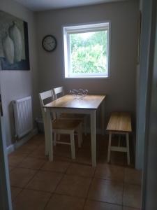einem Esstisch mit 2 Stühlen und einem Fenster in der Unterkunft Boreland Farm in Dunscore