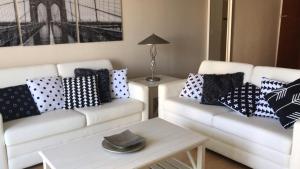 uma sala de estar com 2 sofás brancos com almofadas em Apartamento en la Playa The Tides em Hollywood