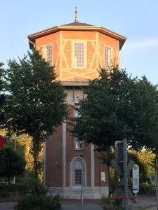 un bâtiment avec une croix en haut dans l'établissement Der Wasserturm, à Niebüll