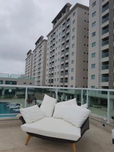 a white couch sitting on a balcony with tall buildings at Salinas Park Rersort in Salinópolis