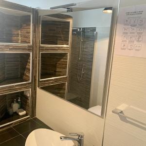 een badkamer met een wastafel, een douche en een spiegel bij Rivamare in Torre Squillace