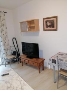 ein Wohnzimmer mit einem Flachbild-TV und einem Tisch in der Unterkunft Camino a Monasterio de piedra in Alhama de Aragón