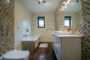 un bagno con vasca, lavandino e WC di Nadwiślańskie Gniazdo a Lucimia