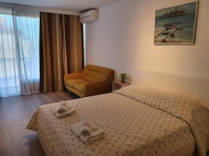 um quarto de hotel com uma cama e uma cadeira em Apartment Sinčić em Novigrad