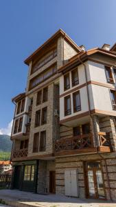 a large stone building with windows on the side of it at Two bedroom apartments in Murphys Lodge in Bansko