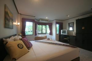 a bedroom with a large bed and a desk at Angus O'Tool's Guesthouse in Karon Beach