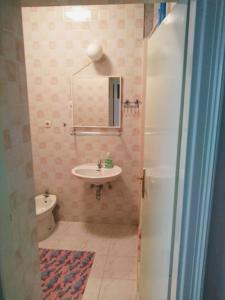 bagno con lavandino, servizi igienici e specchio di Apartment Curri a Pučišća