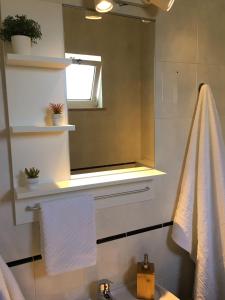een badkamer met een wastafel, een raam en een handdoek bij Carrapateira Lodge in Carrapateira