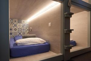 a small bed in a room with a wall at Vert Lodge Chamonix in Chamonix-Mont-Blanc