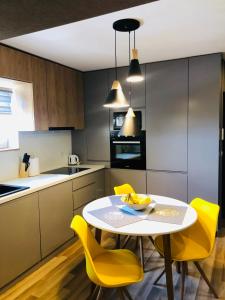 a kitchen with a white table and yellow chairs at GoConcept Studio in Iaşi