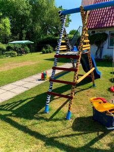 a playground with a ladder and a slide at Domek La Pergola in Łeba
